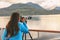 Travel photographer with professional telephoto lens camera on tripod shooting wildlife in Alaska, USA. Scenic cruising