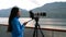 Travel photographer with professional telephoto lens camera on tripod shooting wildlife in Alaska, USA. Scenic cruising