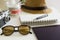 Travel planning concept on table. Traveler`s accessories and items with notebook and money saving jar, sunglasses and hat