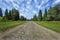 Travel road on the field with green grass and blue sky with clouds on the farm in beautiful summer sunny day. Clean, idyllic, land