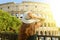 Travel in Rome. Back view of beautiful girl visiting Colosseum landmark at sunset. Summer holidays in Italy