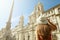 Travel in Rome. Back view of beautiful girl visiting Piazza Navona square landmark in Rome on sunny day. Summer holidays in Italy