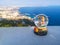 Travel souvenir glass snow globe standing on a white surface, against the background of aerial views of Antalya. Beautiful