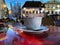 Travel  street cafe Tallinn.Estonia Old town hall square . evening street cafe  ,cup of coffee on table top ,blue glass of wine ,