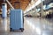 Travel Suitcase. Blue wheeled suitcase standing on the floor in airport terminal. Copy space. Travel background.