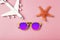 Travel summer background. Sunglasses, airplane and beach accessories on a colored pink background. Tourist vacation