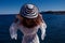 Travel summer vacation standing girl on holiday in white black hat enjoying looking view of ocean
