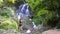 Travel and technology. Young woman in sportswear taking photo of big waterfall on her smartphone.