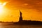 Travel to Manhattan, visit New York. Amazing summer sunset over Statue of Liberty with spectacular dramatic sky.