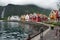 Travel to Norway, a small village on the shore of the fjord, bright houses stand in a semicircle on the embankment, behind the