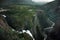 Travel to Norway, waterfalls flow from the mountains into the river at the bottom of a large canyon, top view