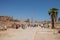 Travel tour group wanders through Karnak Temple. Egyptian landmark with hieroglyphics, decayed