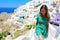 Travel tourist happy woman climbs the stairs in Santorini, Cyclades Islands, Greece, Europe. Girl on summer vacation