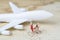 Travel or transportation concept, miniature people couple women help holding baggage walking together with toy airplane on vintage