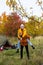 Travel, trekking and hiking concept - couple of hikers having fun near green tent in autumn forest