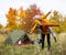 Travel, trekking and hiking concept - portrait of couple in love having fun near green tent in autumn forest