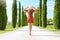 Travel in Tuscany. Young woman walking in beautiful and idyllic landscape of a lane of cypresses in the Tuscan countryside in