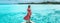 Travel vacation. Elegant asian woman relaxing at luxury pool resort overlooking turquoise ocean in red beach coverup
