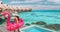 Travel vacation fun tourist woman enjoying luxury summer holidays at Bora Bora overwater bungalow swimming with flamingo