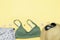 Travel vacation summer flat lay, accessories objects, hat, sunglasses, clothes, bathing suit, seashells on yellow background with