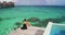 Travel Vacation in Tahiti. Elegant woman in black dress relaxing enjoying view of coral reefs of French Polynesia ocean