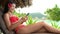 Travel vacation woman using phone texting relaxing on beach at luxury hotel resort