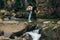 Travel and wanderlust. Stylish woman traveler with backpack standing at river in mountains, hiking