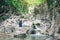 Travel woman standing and enjoy the moment on the rock at waterfall in natural park