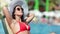 Travel woman wearing trendy sunglasses relaxing during sunbathing at luxury hotel