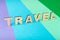 Travel word inscripted with wooden letters on colorful background