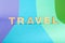 Travel word inscripted with wooden letters on colorful background