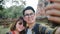 Traveler Asian couple using smartphone taking selfie while spending holiday trip at Ayutthaya, Thailand, Couple enjoy their