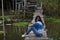 Traveler asian woman posing sitting on the wooden brigde and travel Pakpra canal at Ban Pak Pra fishing village