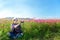 Traveler Asian women sitting and take a photo in the flower field and hand touch cosmos flower, freedom and relax in the flower me