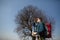 A traveler with a backpack, looking at the map and walking in the countryside. Tree in the background