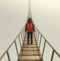 Traveler with a backpack standing on a bridge in the fog