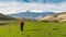 A traveler with a backpack walks in a mountain valley