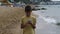 Traveler boy walk on the beach and using smart phone in the evening, chats, write sms. Using a portable handheld device