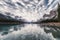 Traveler canoeing on Maligne lake with altocumulus clouds in Jasper