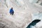 Traveler in a cap and sunglasses is sitting in the snowy mountains on the glacier. Traveler in a natural environment