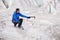 Traveler in a cap and sunglasses is sitting in the snowy mountains on the glacier. Traveler in a natural environment