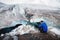 Traveler in a cap and sunglasses is sitting in the snowy mountains on the glacier. Traveler in a natural environment