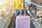 Traveler carry big suitcase on escalator walkway at the airport terminal.