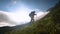 Traveler Caucasian woman walks along the narrow ridge of the peak at sunset. Reaching the top. Young woman practicing a