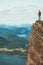 Traveler on cliff mountains over fjord