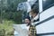 Traveler couple looking paper guide map with roads to choose next camper van journey destination. Travel people lifestyle. Freedom