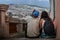 A traveler couple sitting on old stairs of Quito old town, Ecuador. they are with their back turned and a beautiful mount