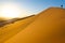 Traveler in the desert, active young woman trekking in hot sandy wilderness, dramatic sunset