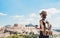 Traveler girl enjoying vacations in Athens, Greece. Young woman wearing hat looking at Acropolis.