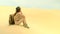 traveler girl sitting on a dune in the desert. No water and energy.